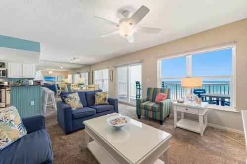 a living room with blue furniture and a view of the ocean at Spacious gulf front condo with beach access in Fort Walton Beach