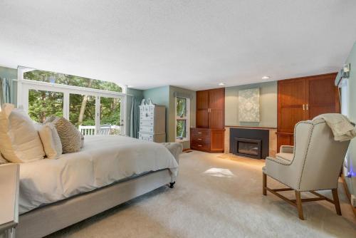 a bedroom with a bed and a chair and a fireplace at Bufflehead Hideaway in Kennebunk