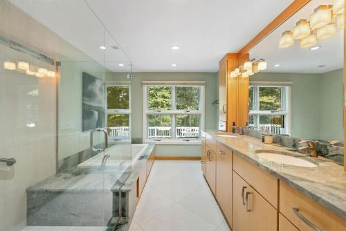 a bathroom with two sinks and two mirrors at Bufflehead Hideaway in Kennebunk