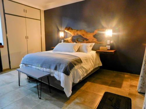 a bedroom with a large bed and a table at Mountain Manor in Louis Trichardt
