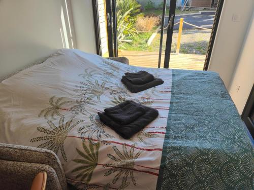 two black towels sitting on a table with a blanket at L'Escale in Penvénan
