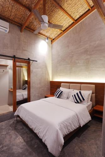 a bedroom with a large bed with a ceiling fan at Tigbaw in Mactan