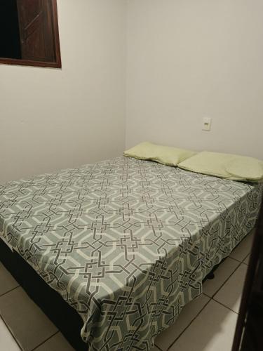 a bed in a room with a bedspread on it at Casa de clecia in Natal