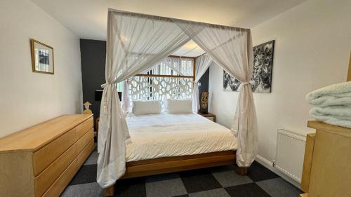 a bedroom with a canopy bed and a window at Four Poster Hideaway in Chacombe