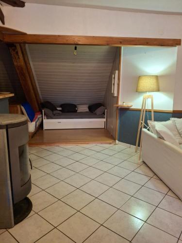 a small room with a bed and a tiled floor at le sans soucis in Bellevaux