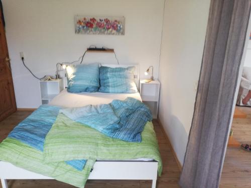 a bedroom with a bed with blue and green sheets at Perdöhl-Wittenburg in Wittenburg