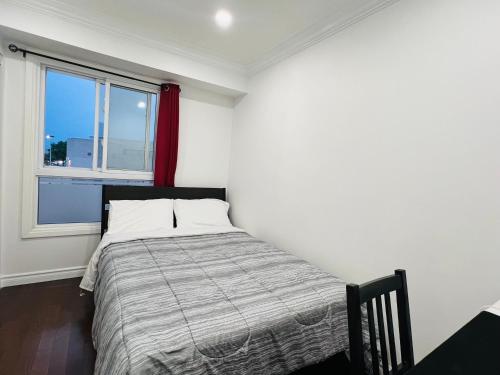 a bedroom with a bed and a window at ComfyRoom in Toronto