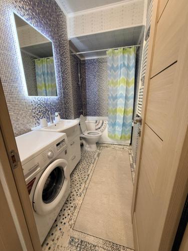 a bathroom with a washer and a washing machine in it at New House Strișca in Chişinău
