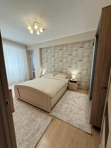 a bedroom with a large bed and a brick wall at New House Strișca in Chişinău