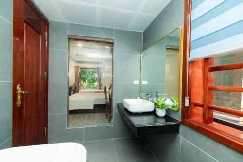 a bathroom with a sink and a mirror at Champs De Tam Coc Hotel in Vũ Lâm