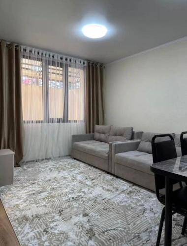 a living room with a couch and a table at Радуга in Chon-Sary-Oy