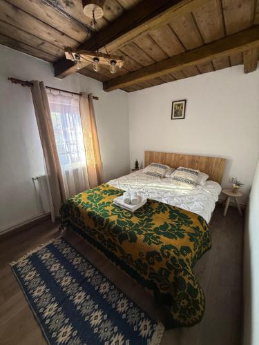 a bedroom with a bed with a green comforter at Casa cu Lavanda in Petroşani