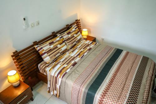 a bedroom with a large bed with two lamps on tables at Assinie's apartment in Assinie