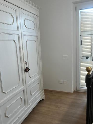 a white door in a room with a window at Sotto la Cupola in Montefiascone