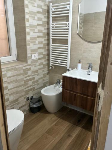 a bathroom with a sink and a toilet and a mirror at Sotto la Cupola in Montefiascone
