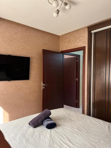 a bedroom with a bed with a purple towel on it at Apartment sunah in Nador