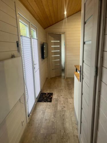 a hallway of a tiny house with a door at Domek nad jeziorem Kamień in Kowalewo