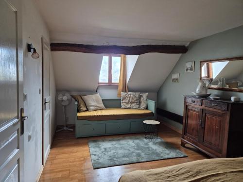 a small room with a couch and a window at Le figuier in Benayes