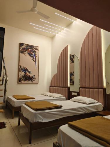 two beds in a room with at Agatya Homestay in Kolhapur