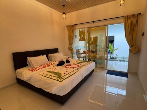 a bedroom with a bed and a large window at Vegas Luxe Thoddoo in Thoddoo
