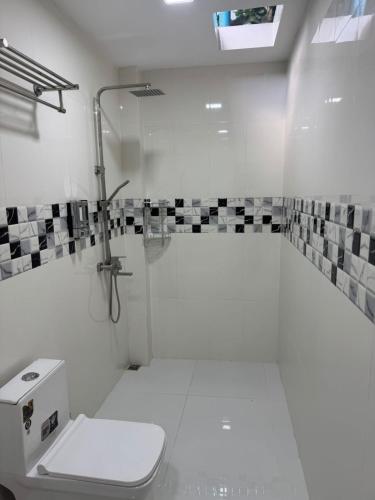 a white bathroom with a shower and a toilet at Vegas Luxe Thoddoo in Thoddoo