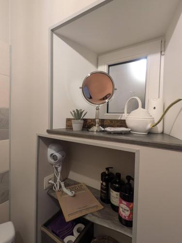 a mirror on top of a shelf in a bathroom at Gala Kambaris in Myza Bene