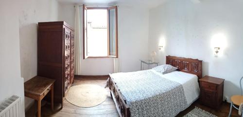 a bedroom with a bed and a window at Maison de village commingeoise in Miramont-de-Comminges