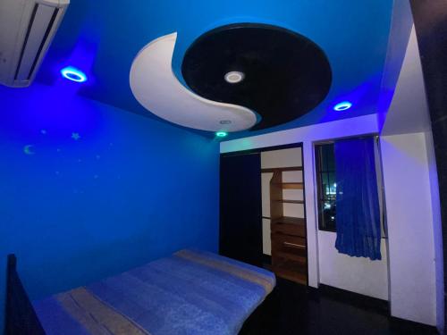 a blue bedroom with a crescent moon on the ceiling at Casa Cristian in Caracas