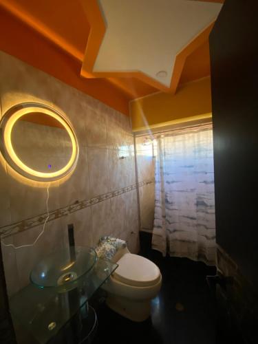 a bathroom with a toilet and a sink and a mirror at Casa Cristian in Caracas