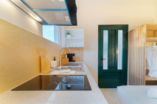 a kitchen with a sink and a black door at Vasiliki Petri Olive House in Petra