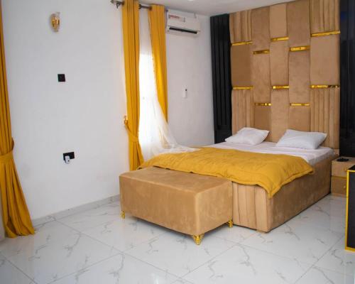 a bedroom with a bed with a yellow blanket at Isuki apartment in Benin City