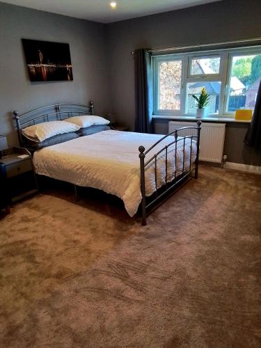 a bedroom with a bed and a large window at Large double room with spacious ensuite in Southbourne