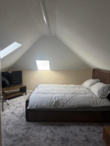 a bedroom with a bed and a television in a attic at Easy living stays Burton on Trent in Burton upon Trent