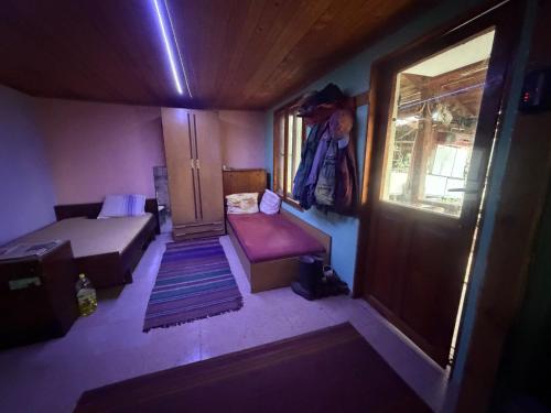 a small room with a bed and a window at Kazanlak SHELTER HOUSE ACCOMODATION 1 Room 1 Bed, No Water, WC is Outhouse, Dirt Road, Dog in the Garden, Genius Points Welcome! Къща за Подслон в Казанлък, Без Вода! in Kazanlŭk