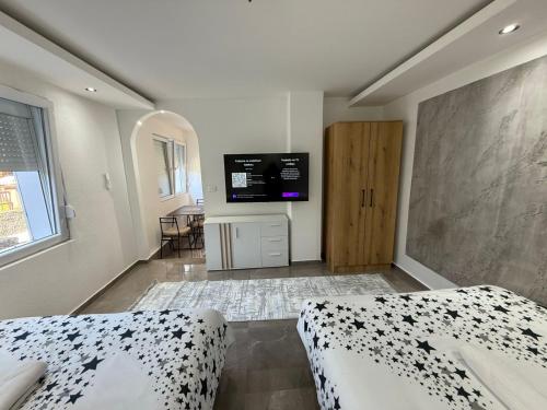 a bedroom with two beds and a flat screen tv at Stan na dan Berane in Berane