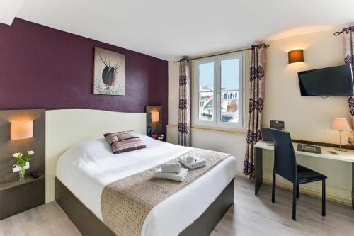 a hotel room with a bed and a desk at Cristal Hôtel Restaurant - Logis Hotels in Saumur