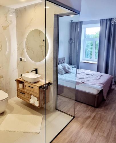 a bathroom with a mirror and a bed and a sink at Dundagas rezidence in Dundaga