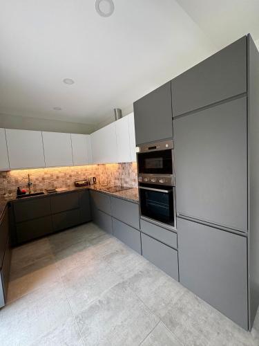 a kitchen with gray and white cabinets and appliances at Casa Helena in Tavira