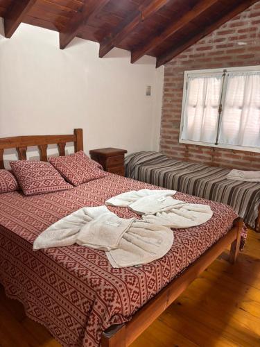 a bedroom with two beds with towels on them at Complejo Aldea Champaqui in Villa General Belgrano