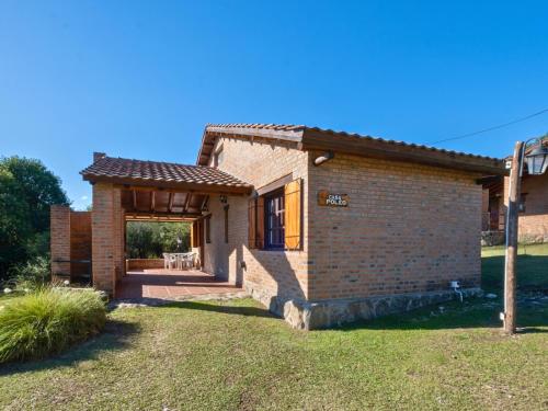 a small brick house with a patio at Sombra de Liebre Casas de Campo en Villa General Belgrano in Villa General Belgrano
