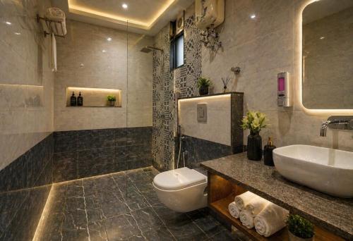 a bathroom with a sink and a toilet and a tub at Hotel Belwood De Near Delhi Airport IGI in New Delhi
