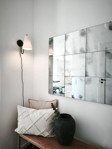 a room with a vase on a bench with a mirror at Vila Karup Modern Scandinavian Holiday Home in Båstad