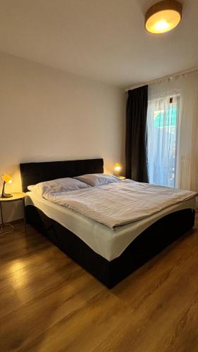 a large bed in a bedroom with a window at Riverside Vrchlabí in Vrchlabí