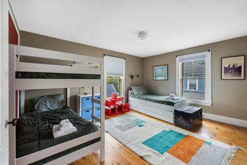 a bedroom with two bunk beds and a window at Antique Charmer Walk to Downtown KBK in Kennebunk