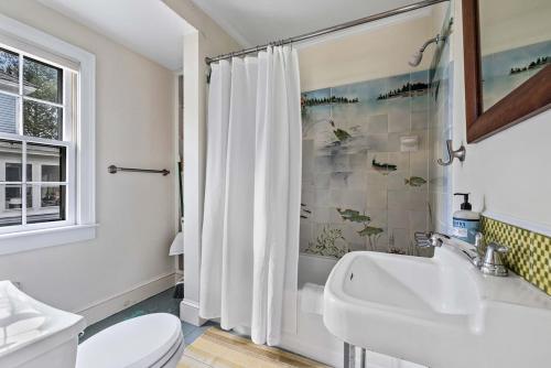 a white bathroom with a sink and a toilet at Antique Charmer Walk to Downtown KBK in Kennebunk