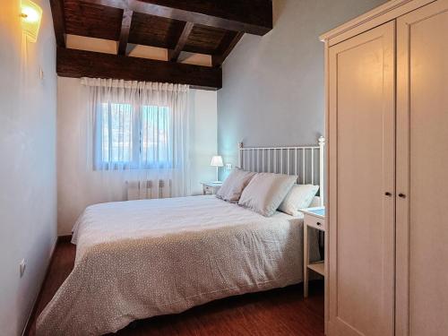 a bedroom with a white bed and a window at Casa Puerta de Albarracín in Albarracín