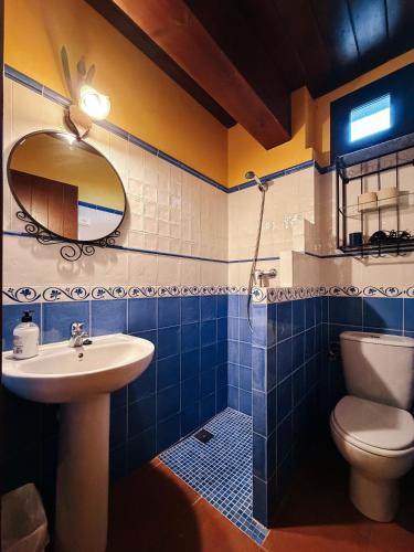 a bathroom with a sink and a toilet and a mirror at Casa Puerta de Albarracín in Albarracín