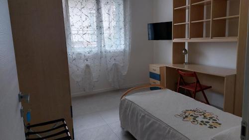 a bedroom with a bed and a desk and a window at B&B Montegrappa in Mestrino