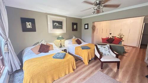 a bedroom with two beds and a couch at Artzy's Garden View 1km to Olivedale Clinic in Northriding