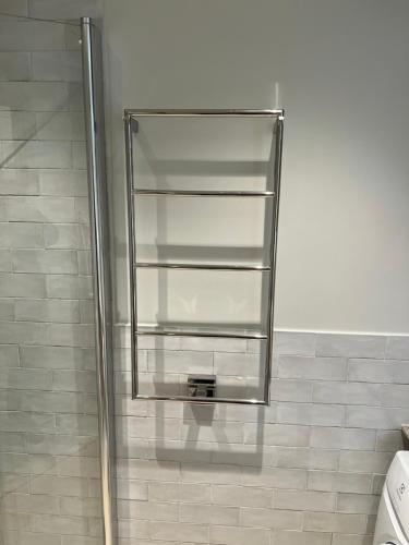 a shower with a glass shelf in a bathroom at Modern Apartment i Solna in Solna